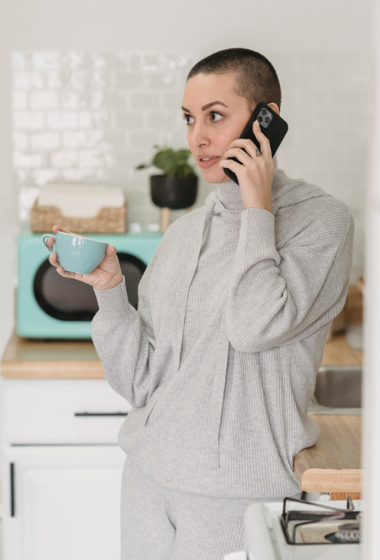 Person standing in kitchen on the phone